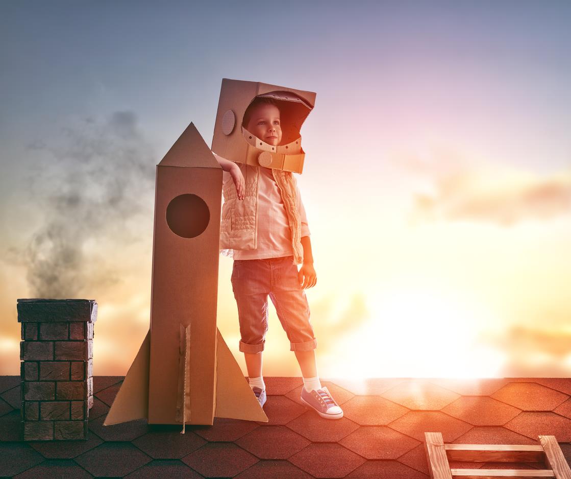 Bambino sul tetto di una casa vestito da astronauta