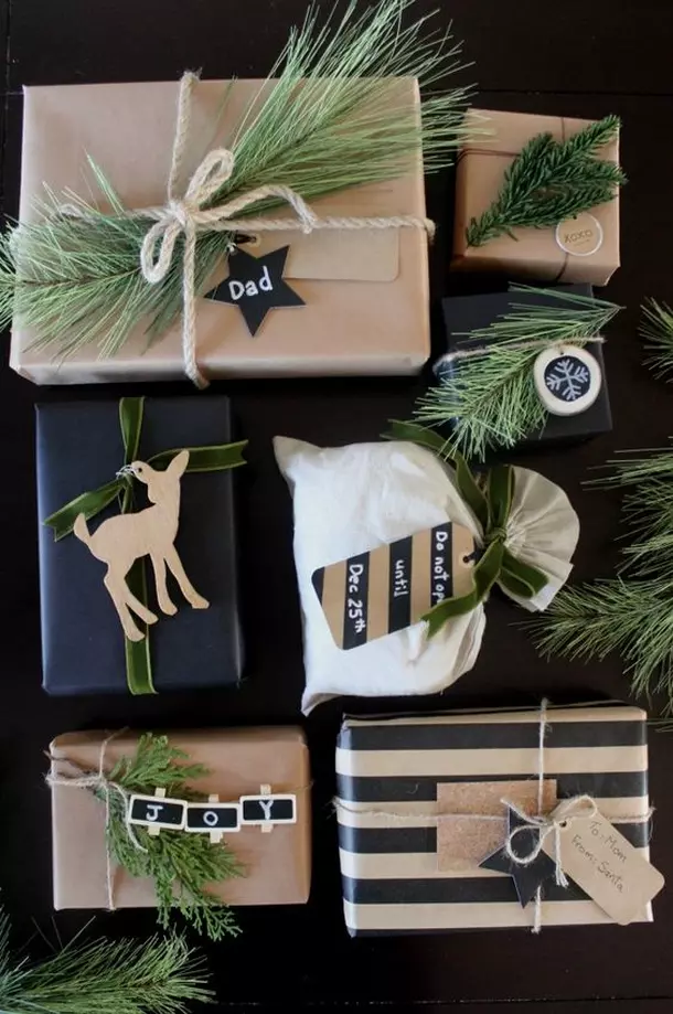 Pacchetti di Natale decorati con rami di pino