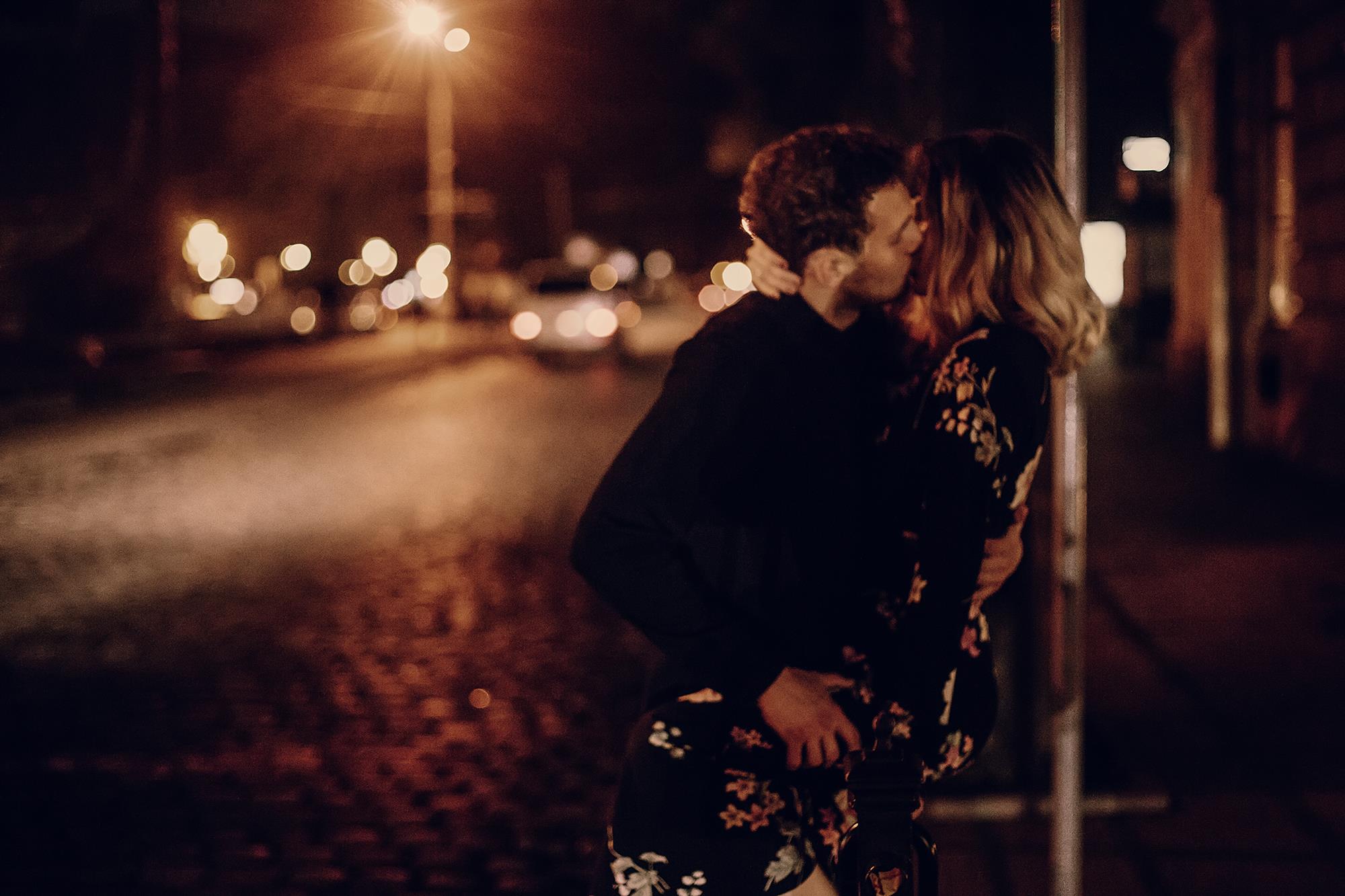 Coppia si bacia lungo la strada di notte