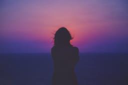 Donna di spalle guarda il tramonto