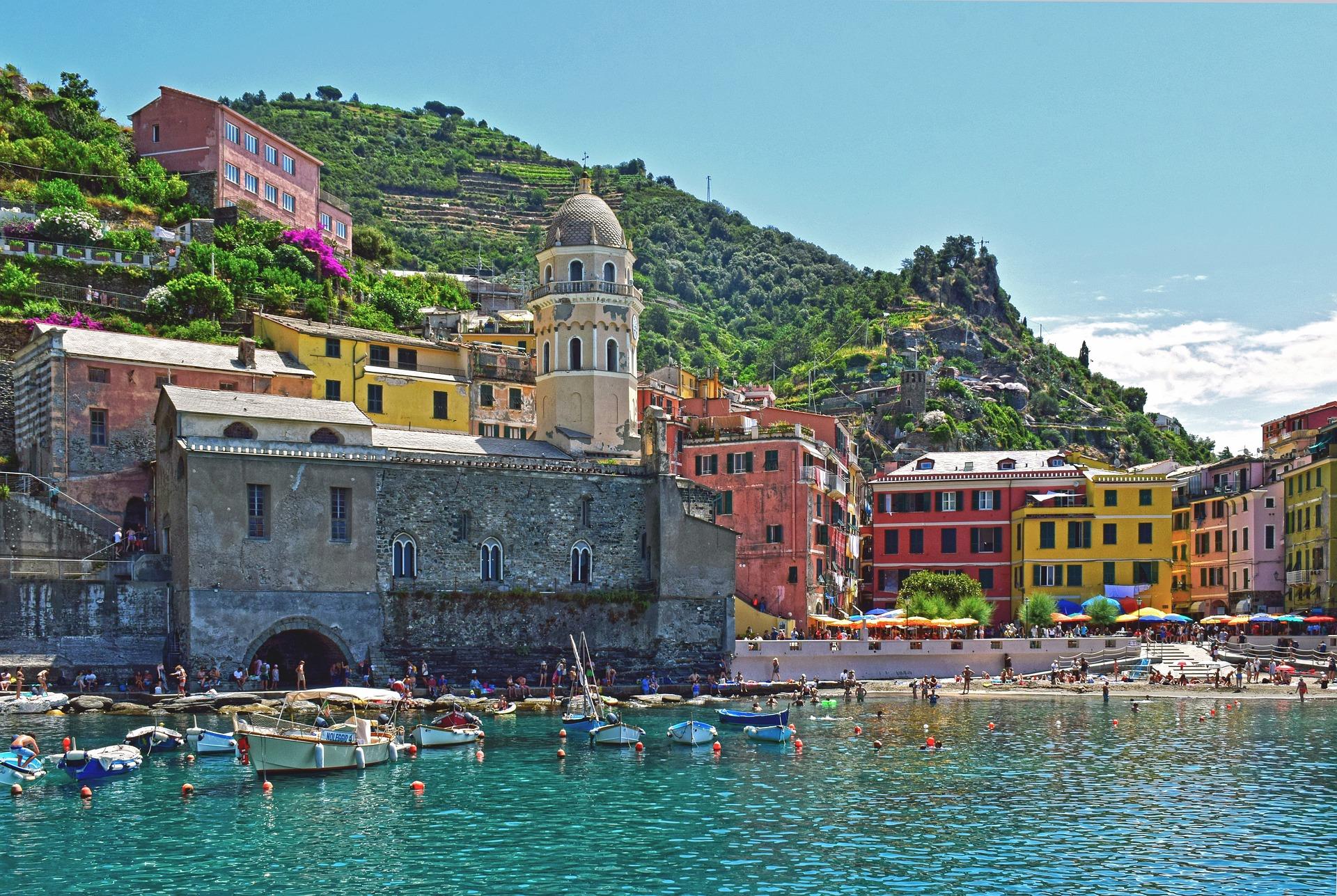 Foto del porticciolo di Vernazza con edifici, spiaggia e barche