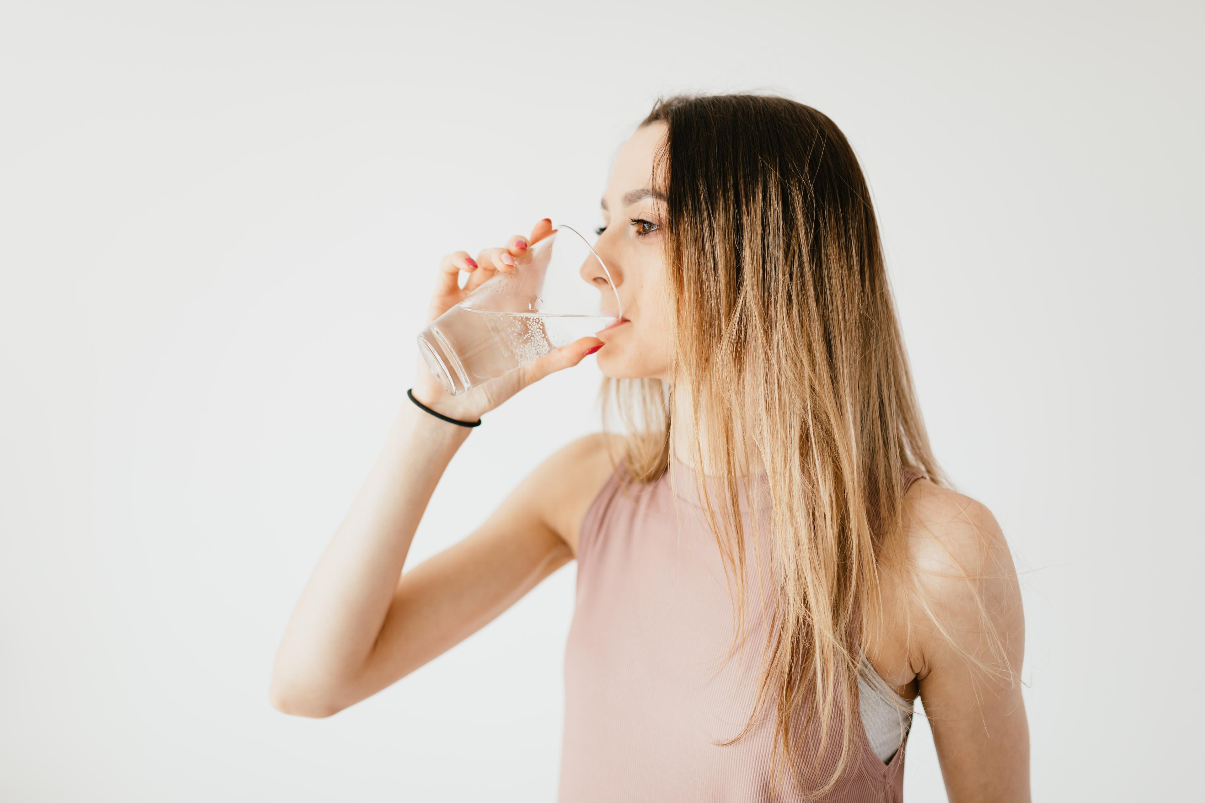 Ragazza molto magra che beve acqua