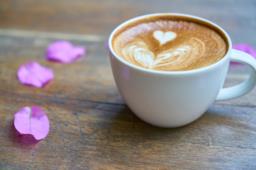 Tazzina di caffè con petali di rosa