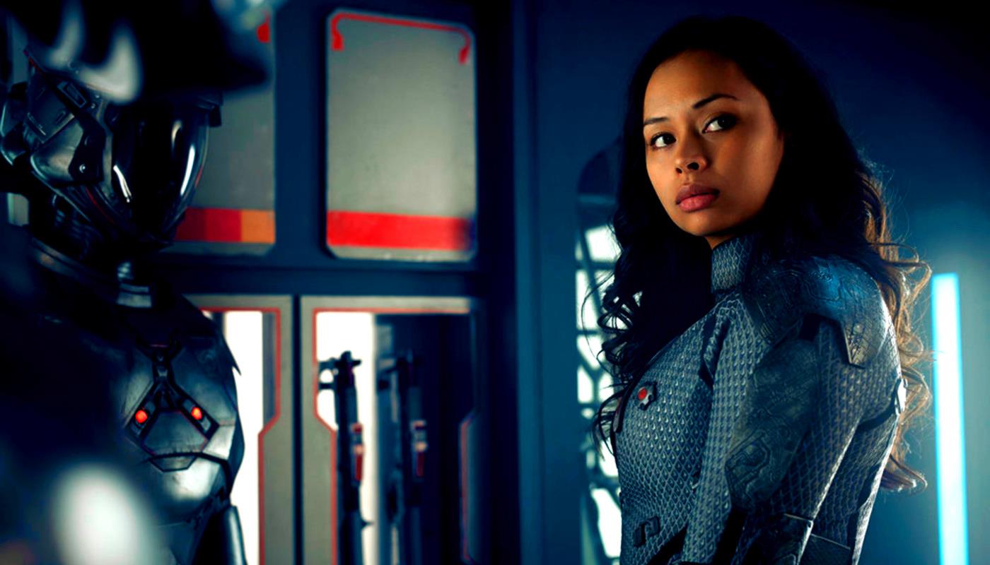 Mezzobusto di Frankie Adams nell'uniforme di Bobbie Draper, di fronte alla sua tuta potenziata
