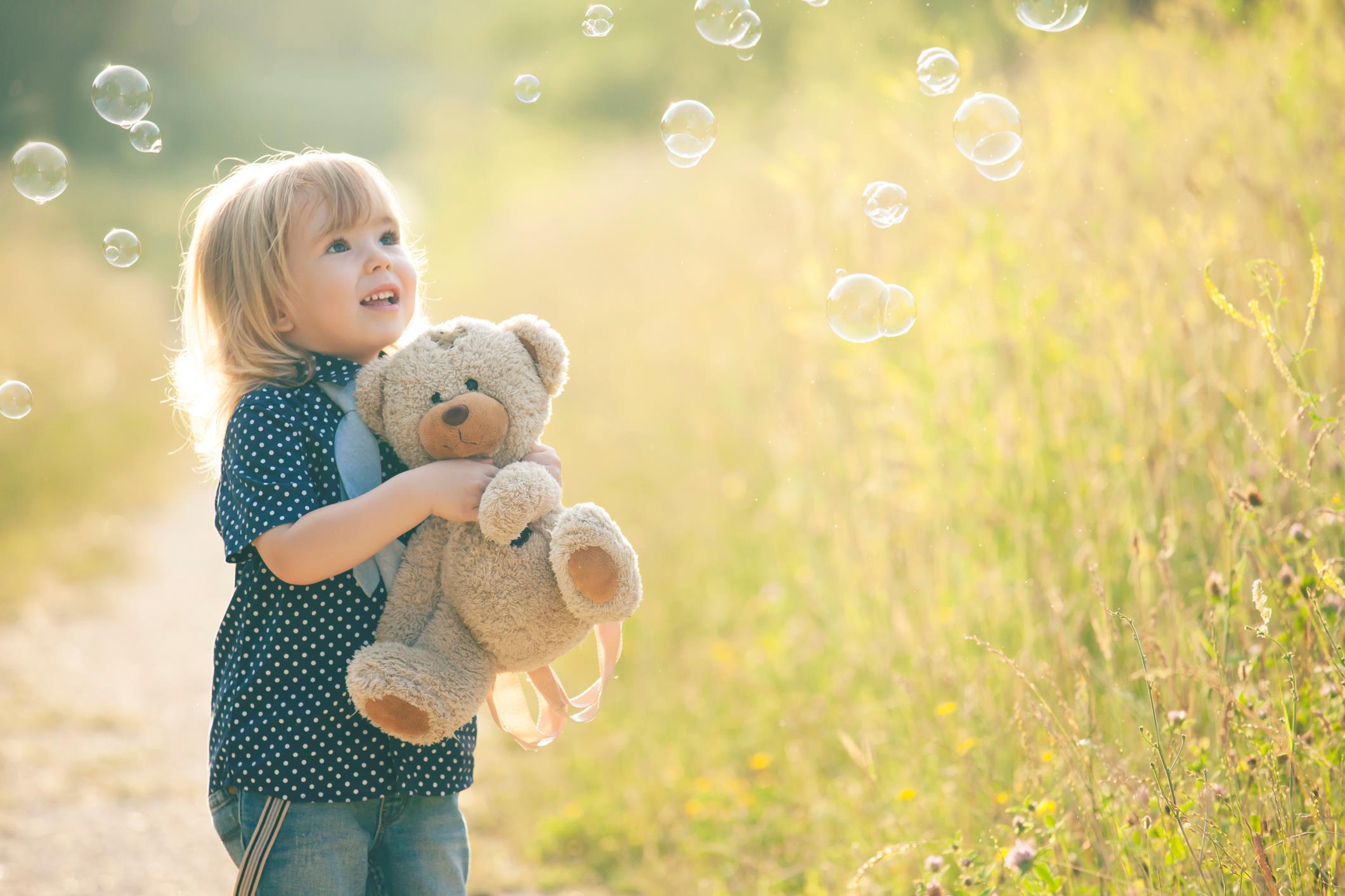 Bambina con un peluche in braccio
