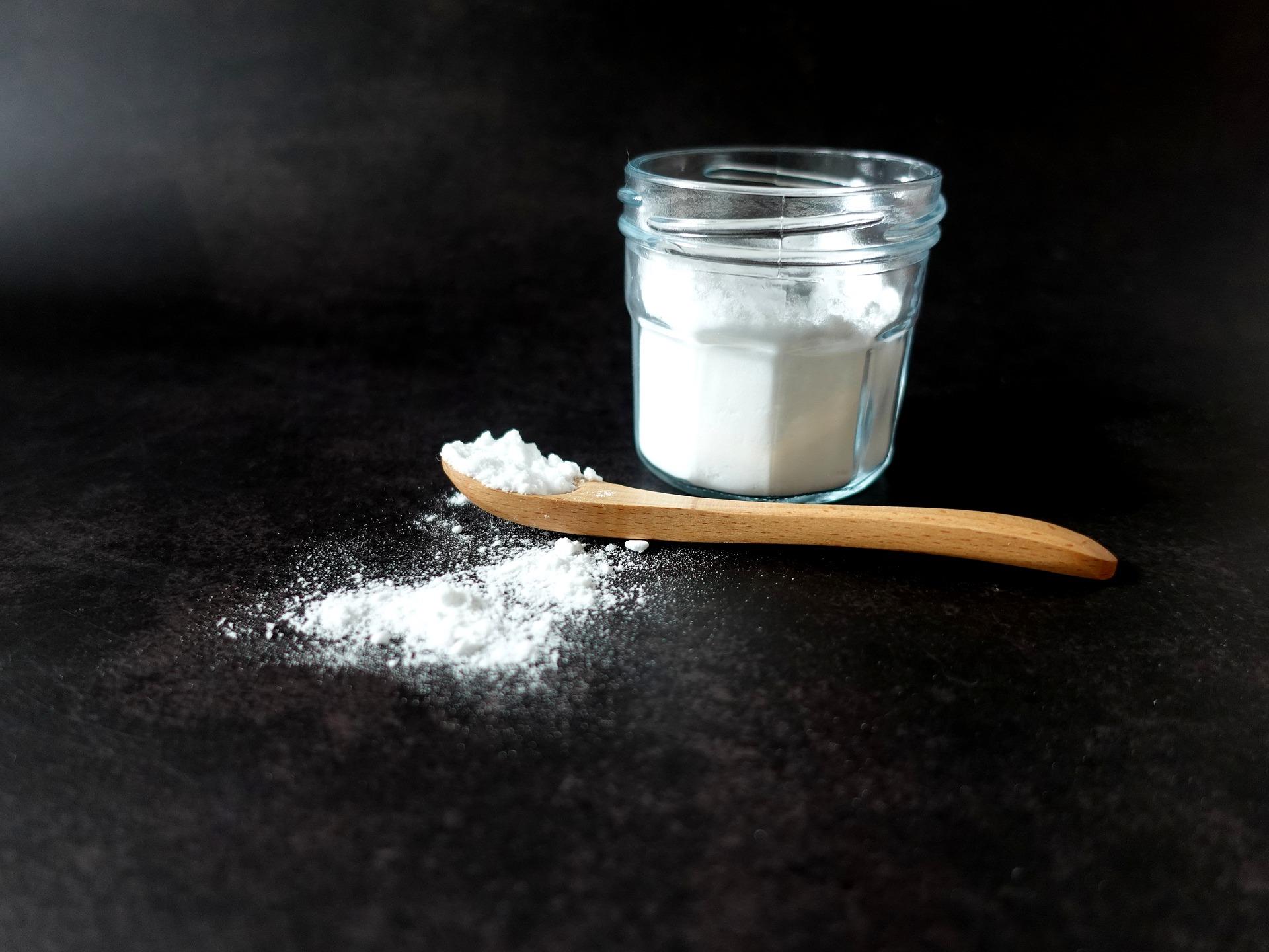 Bicarbonato di sodio in vasetto e cucchiaio