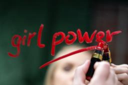Ragazza scrive Girl Power con il rossetto sullo specchio