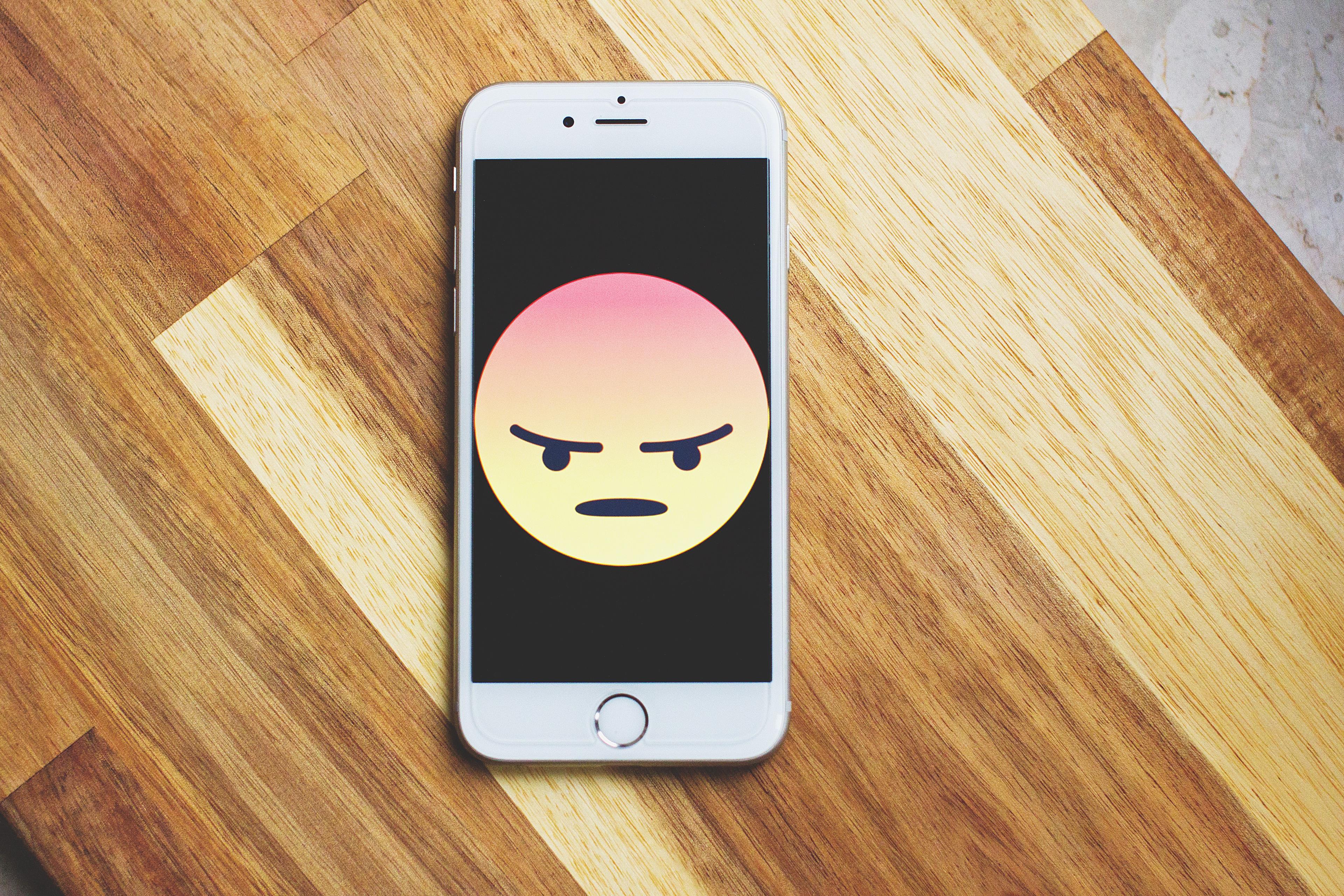 Smartphone con emoji rabbiosa