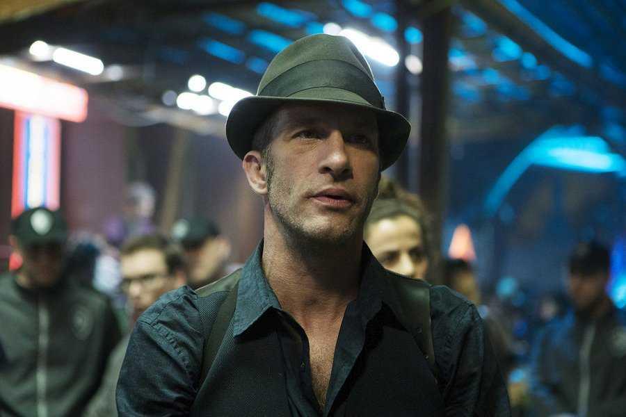 Mezzobusto di Thomas Jane nei panni del detective Josephus Miller, sullo sfondo i corridoi della stazione di Ceres.
