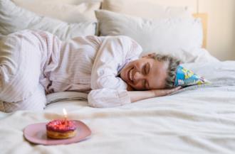 Ragazza sul letto con una tortina di compleanno 
