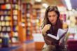 Ragazza legge un libro in biblioteca