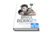 Bruce Dickinson in posa, con il dito indice alzato a puntare la grafica di un pulsante