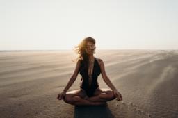 Una ragazza pratica yoga sulla spiaggia