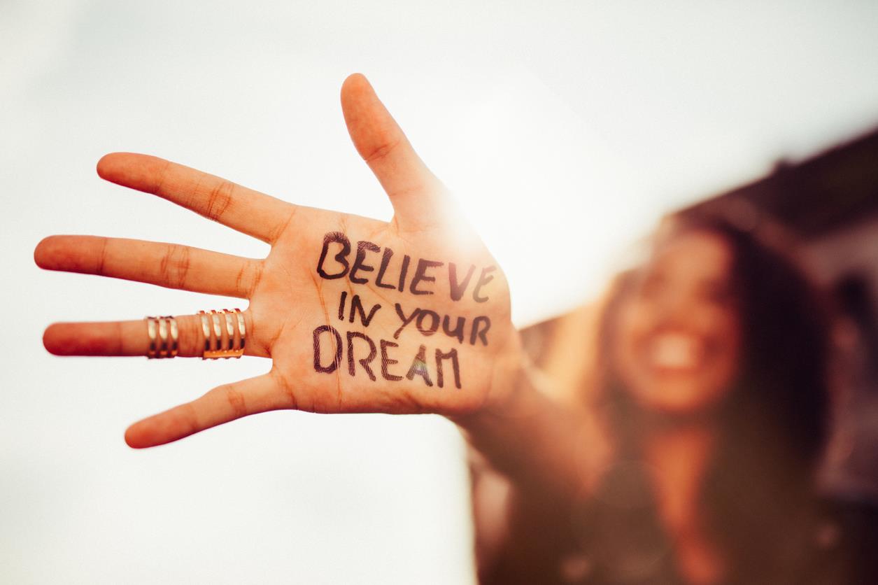 Una ragazza mostra una mano con la scritta credi nei tuoi sogni