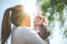 Una donna tiene in braccio una bambina con orecchie da coniglio