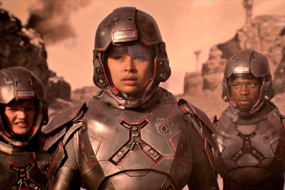 Mezzibusti di Frankie Adams nei panni di Bobbie Draper e compagni di squadra in tuta spaziale, sullo sfondo di Marte
